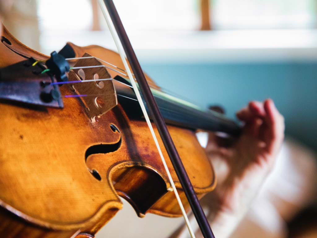 Student practicing viola with teacher
